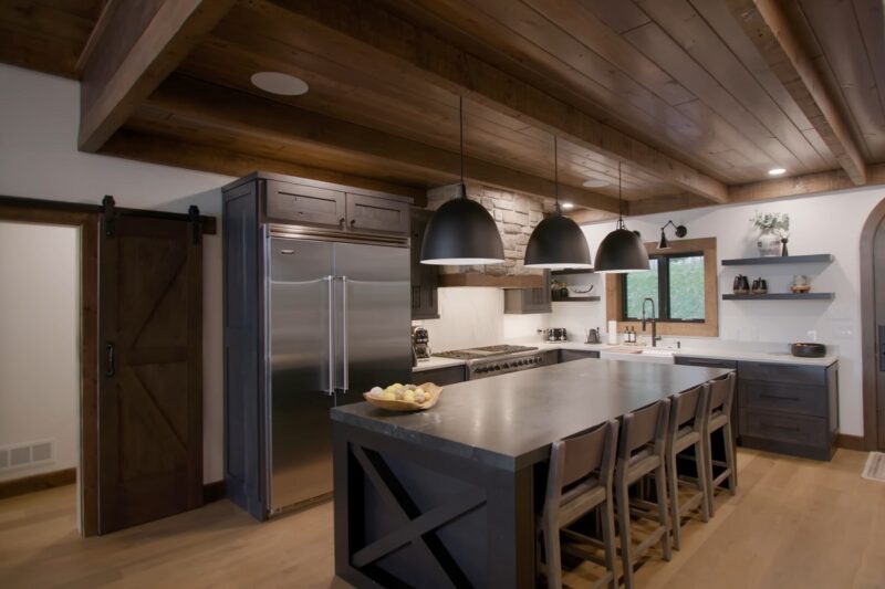 A stylish cabin kitchen with dark wooden cabinets, a large island