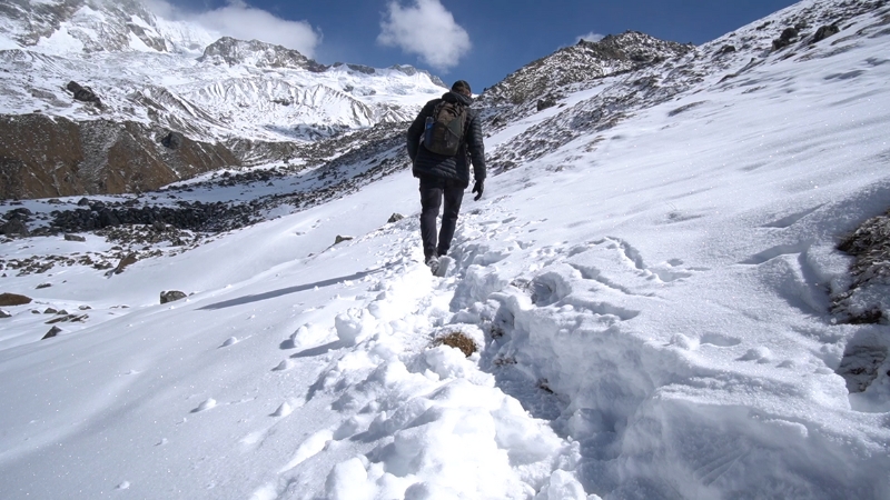 A Solo Traveler Trekking Through Snowy Terrain, Perfect for Solo Backpacking Adventures in The Mountains