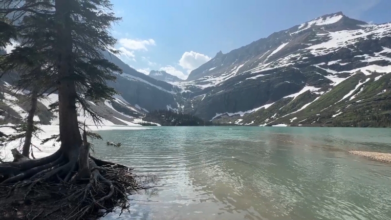 A View of A Lake Surrounded by Snow-Capped Mountains in Glacier National Park During Spring