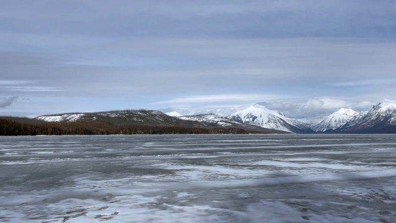 A Winter View of Glacier National Park with Snow-Covered Mountains and Frozen Water